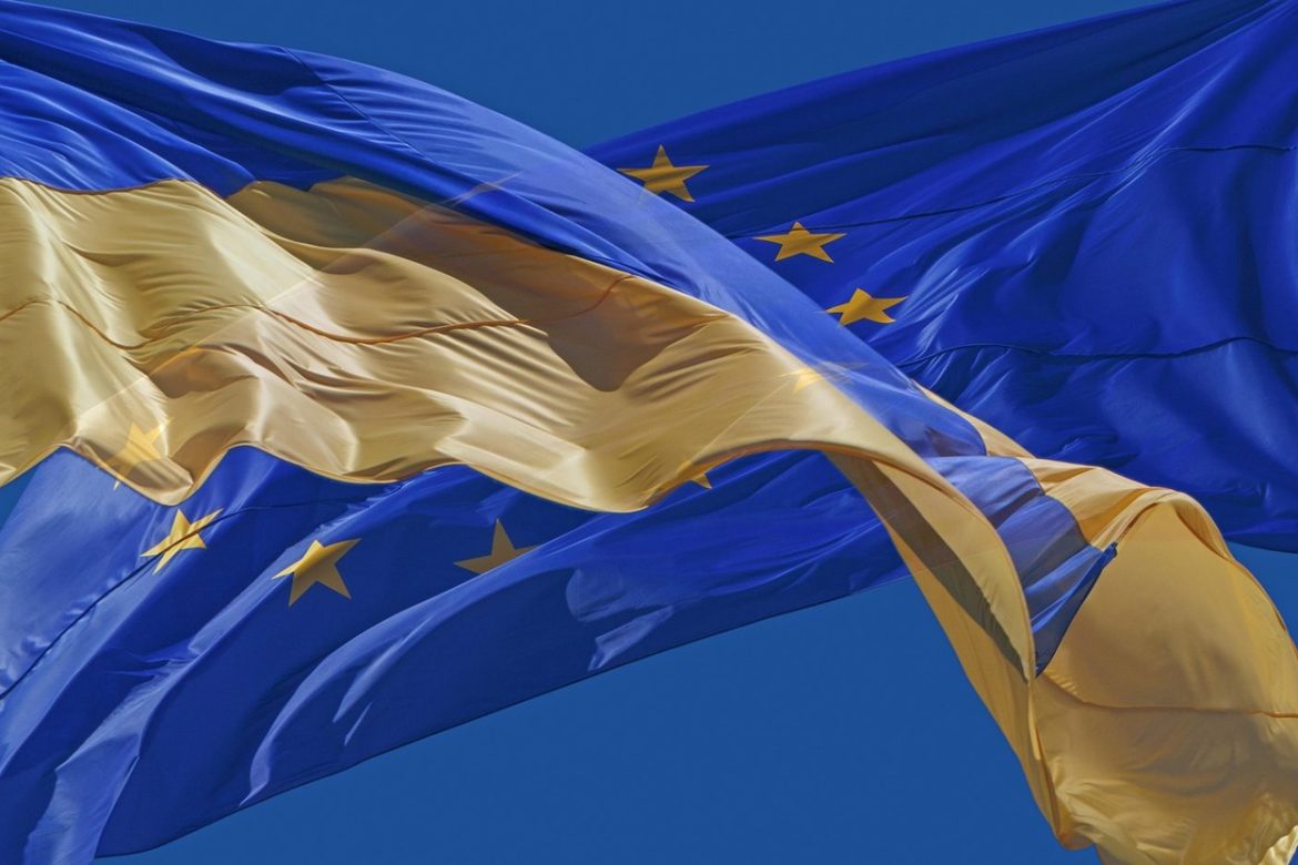 flags of Ukraine and European Union against blue sky